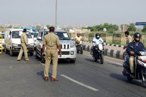 Police personnel check IDs and passes of commuters | See Pics