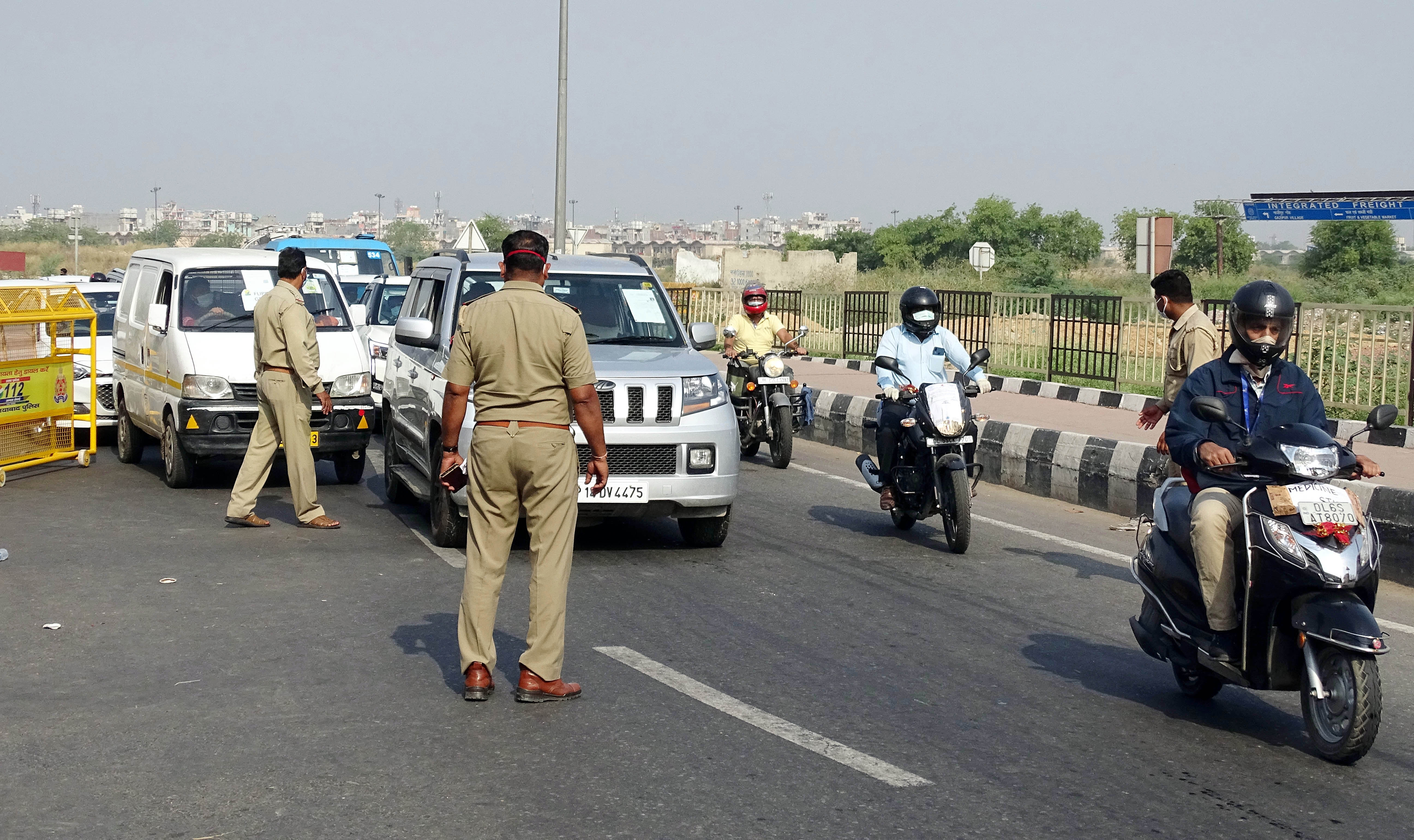 Police personnel check IDs and passes of commuters | See Pics