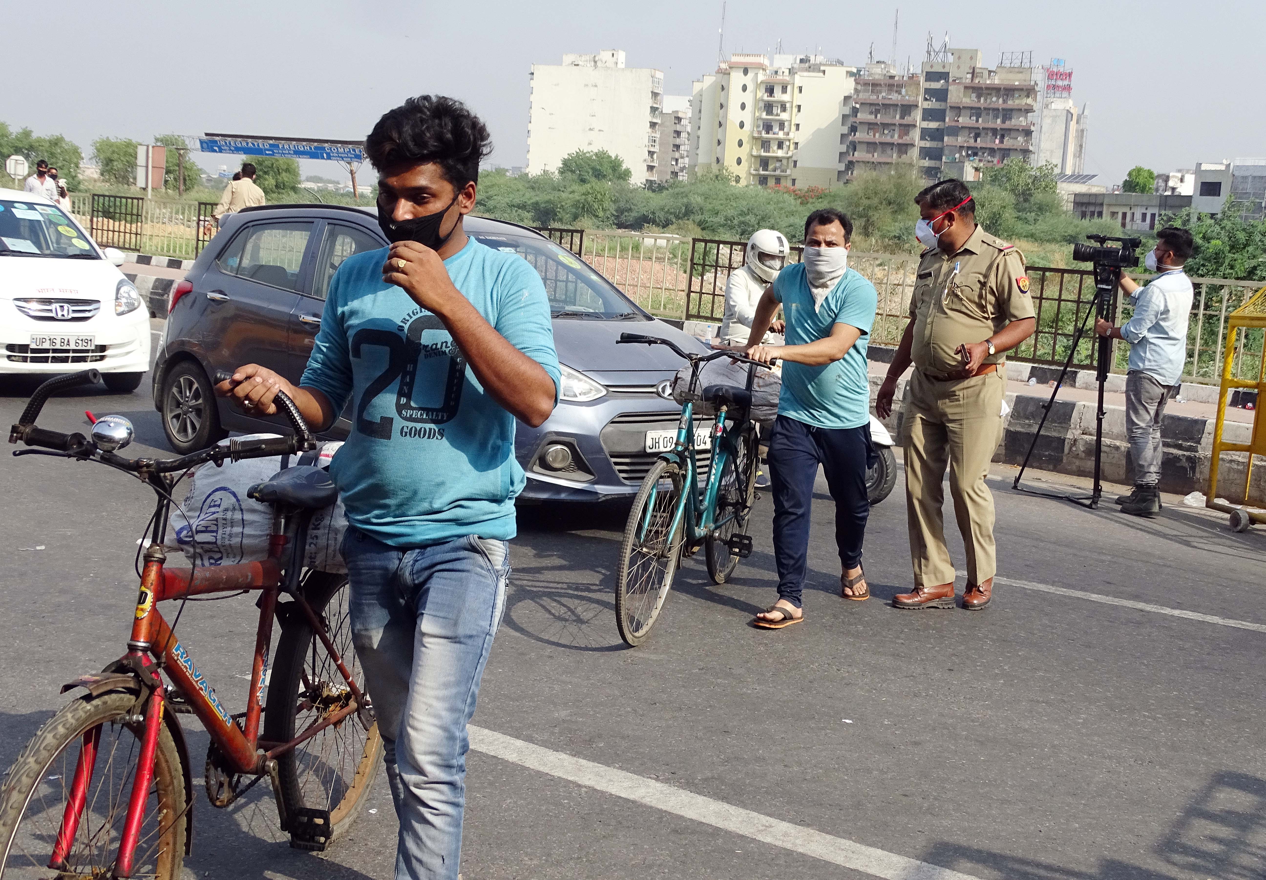 Police personnel check ids and passes of commuters amid lockdown due to coronavirus pandemic