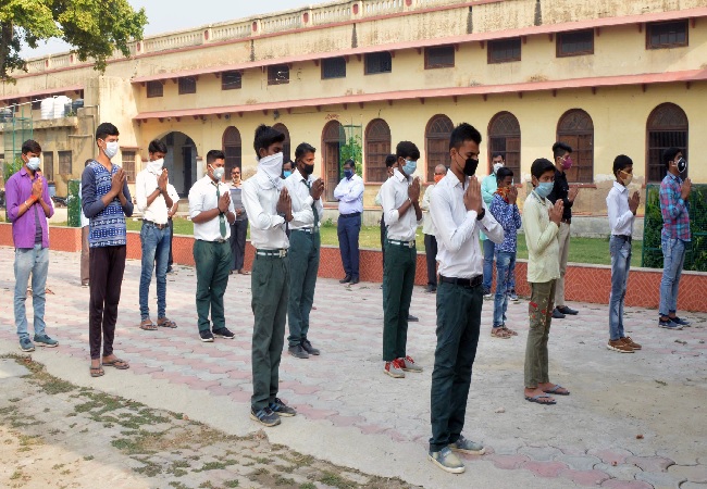 ody temperature of students is being checked as they arrive at school which reopened after COVID-19 lockdown, in Lucknow on Monday.