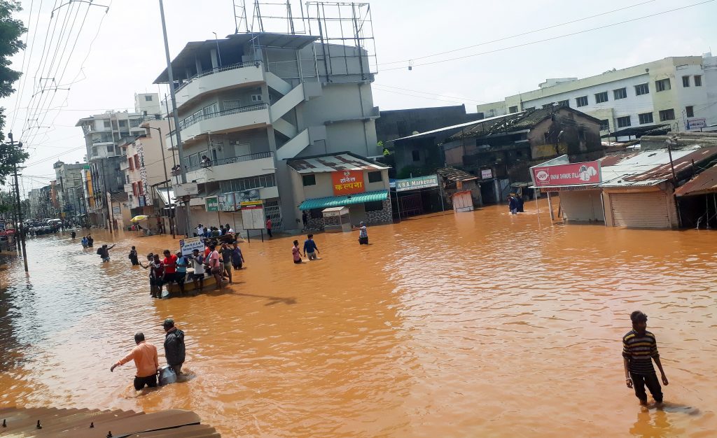 People wade through a flood-affected area following a downpour