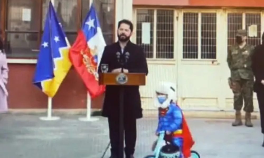 WATCH: Chilean President makes speech after plebiscite, little kid dressed as Superman encircles him on cycle